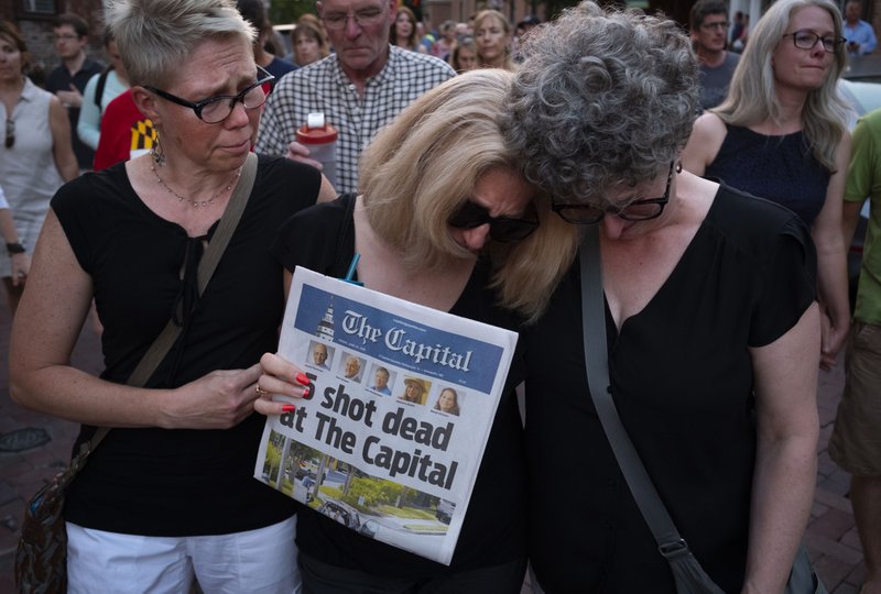 Andrea Chamblee, center, widow of reporter John McNamara, at a vigil in downtown Annapolis, Maryland, to honor the five journalists slain in the mass shooting at the Capital Gazette on June 29, 2018. With her are Cherie Baron, left, and sister Cindy Chamblee, who sang at John and Andrea's wedding. 