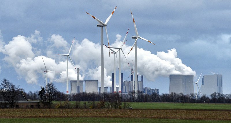 Renewable and fossil-fuel energy is produced when wind generators are seen in front of a coal fired power plant near Jackerath, Germany, Friday, Dec. 7, 2018. (AP Photo/Martin Meissner)