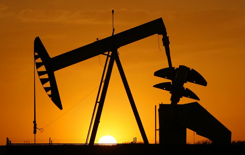 FILE - In this March 22, 2012, file photo, a pumpjack is silhouetted against the setting sun in Oklahoma City. The average U.S. price of regular-grade gasoline has plummeted 22 cents a gallon over the past three weeks, to $2.51. Industry analyst Trilby Lundberg of the Lundberg Survey said Sunday, Dec. 9, 2018, that falling crude oil costs are the main reason for the decrease at the pump. (AP Photo/Sue Ogrocki, File)