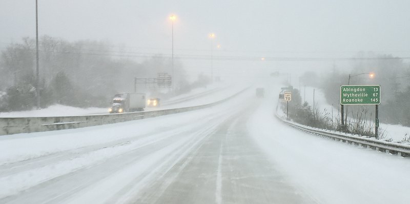 Interstate 81 is covered by snow early Sunday, Dec. 9, 2018, in Bristol, Va. A storm spreading snow, sleet and freezing rain across a wide swath of the South has millions of people in its path, raising the threat of immobilizing snowfalls, icy roads and possible power outages. (Andre Teague/The Bristol Herald-Courier via AP)

