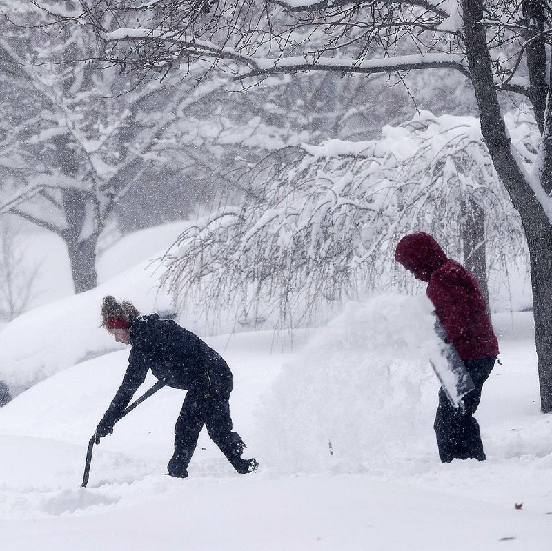 A couple shovel snow from their driveway Sunday in Greensboro, N.C. A strong winter storm caused icy roads, heavy snowfall and power failures throughout the South over the weekend.