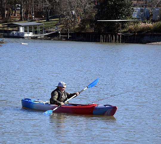 The Sentinel-Record/Grace Brown- Tucker Mitchell, 11, of Hot Springs paddles a kayak out into a cove on Lake Hamilton on Sunday, December 9, 2018. 