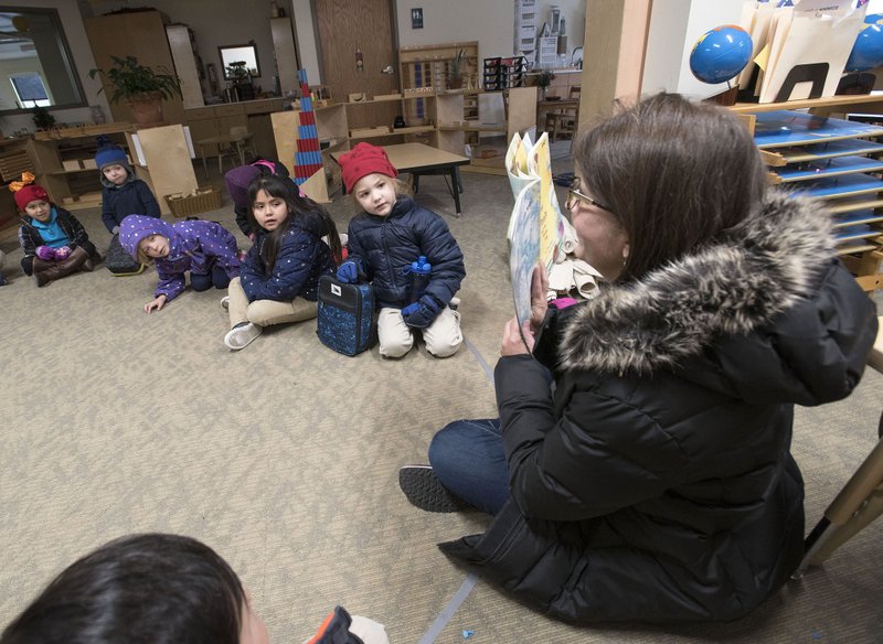 NWA Democrat-Gazette/SPENCER TIREY Phyllis Hunter (right) reads a story to her kindergarten class Friday at the Ozark Montessori Academy in Springdale before the class goes to recess. The LISA Academy, a central Arkansas charter school system, will be taking over Ozark Montessori Academy under an agreement the two organizations will propose to the state early next year.