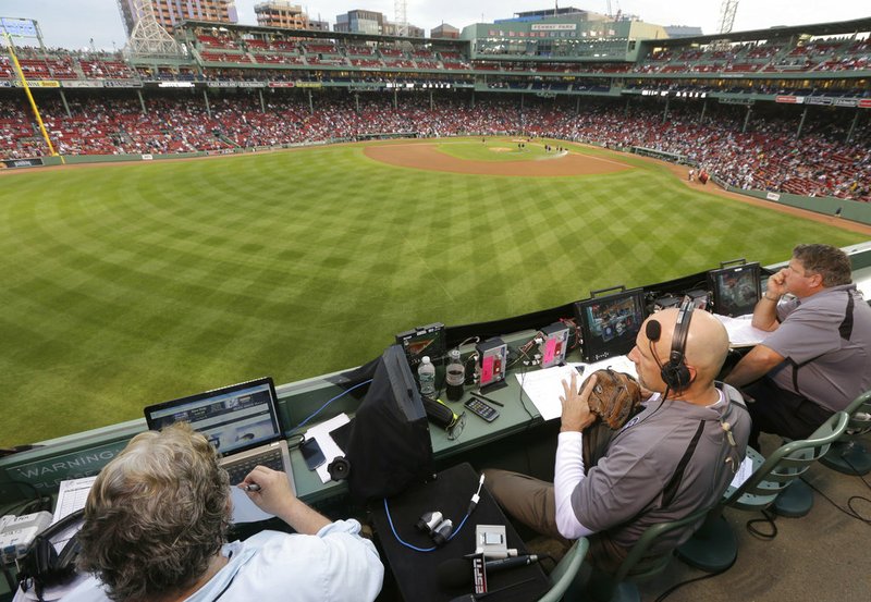 FILE - In this Aug. 3, 2014, file photo, ESPN television broadcasters prepare to cover a baseball game between the New York Yankees and the Boston Red Sox from the top of the Green Monster at Fenway Park, moments before the game, in Boston. ESPN plans to announce it will move up the starting time of the nationally televised game by one hour, with the first pitch planned for shortly after 7 p.m. EDT. The network intends to make the announcement on Monday, Dec. 10, 2018, at the winter meetings, a person familiar with the decision told The Associated Press. The person spoke on condition of anonymity Sunday because the announcement had not yet been made. (AP Photo/Steven Senne, File)