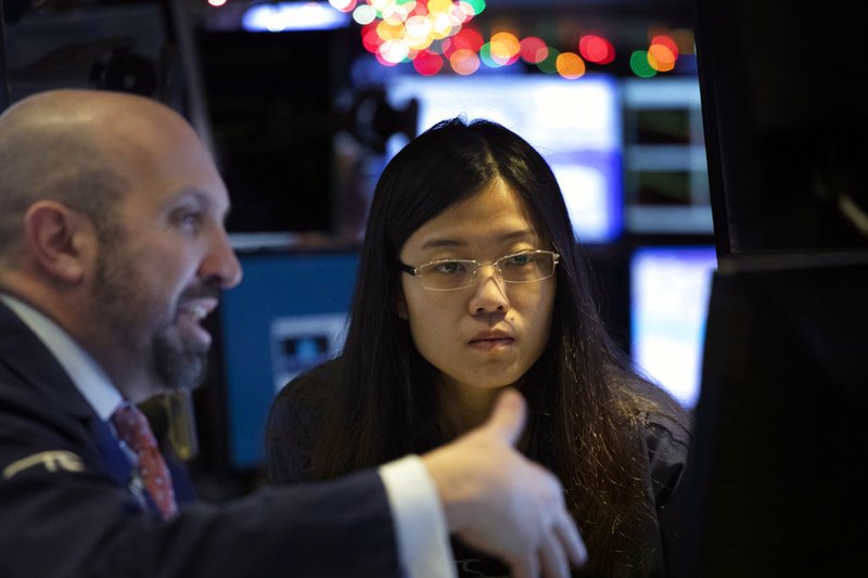Stock traders James Denaro, left, and Vera Liu follow stock prices at the New York Stock Exchange, Monday, Dec. 10, 2018. Stocks are wobbling between small gains and losses in the early going on Wall Street as trading settles down following huge losses last week. (AP Photo/Mark Lennihan)