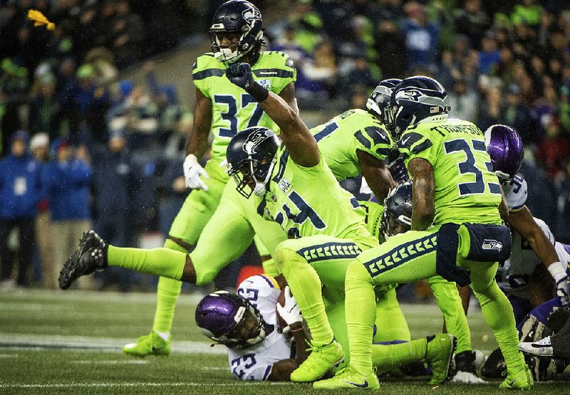 Holding back Seattle Seahawks linebacker Bobby Wagner (center) stops Minnesota Vikings running back Latavius Murray on a fourth and 1 in the third quarter Monday at CenturyLink Field in Seattle. The Seahawks held the Vikings scoreless until the fourth quarter as they won 21-7 to move to the brink of wrapping up a wild-card spot in the NFC.