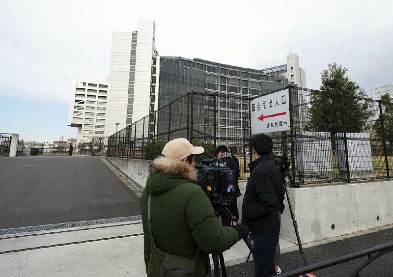 Journalists stand watch Monday outside the Tokyo jail where former Nissan Chairman Carlos Ghosn is being detained after Japanese prosecutors indicted him on charges of underreporting his pay in securities filings. 