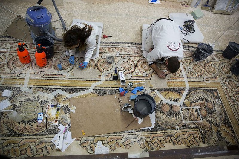 Restoration experts work on a mosaic inside the Church of the Nativity, built atop the site where Christians believe Jesus Christ was born, in the West Bank city of Bethlehem on Thursday.