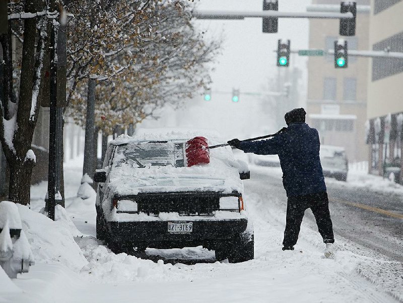 John Woodrum shovels snow and ice off his vehicle on Sunday in Roanoke, Va. A massive storm brought snow, sleet, and freezing rain across the South on Sunday — causing icy roads, immobilizing snowfalls and power losses to hundreds of thousands of people.