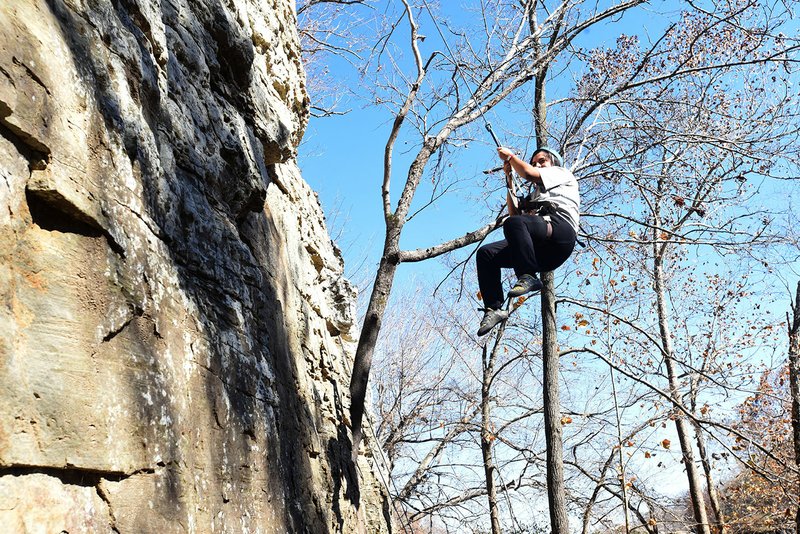 NWA Democrat-Gazette/FLIP PUTTHOFF Jasmine Reyes swings across the rock while rapeling down the bluff at Lincoln Lake.