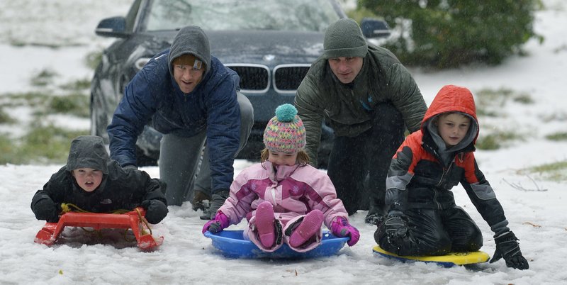 The Associated Press SUNDAY SNOW: Dan Weber and Alex McCoy push sledders, from left, Jack Weber, Allie McCoy and Hudson McCoy, Sunday in the Freedom Park area in Charlotte, N.C.