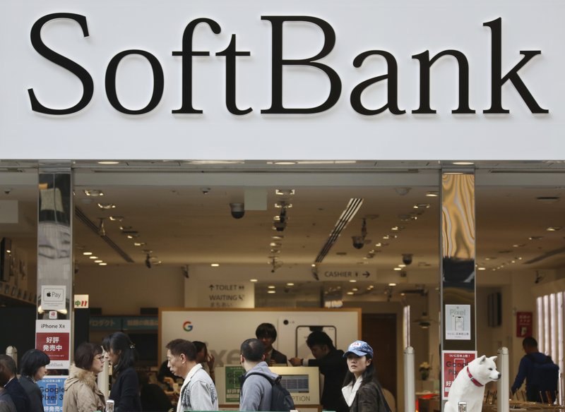 FILE - In this Dec. 4, 2018, file photo, people walk past in front of a SoftBank shop at Ginza shopping district in Tokyo. SoftBank Group Corp. says the price for the initial public offering of its Japanese mobile subsidiary has been set at 1,500 yen ($13) a share. (AP Photo/Koji Sasahara, File)