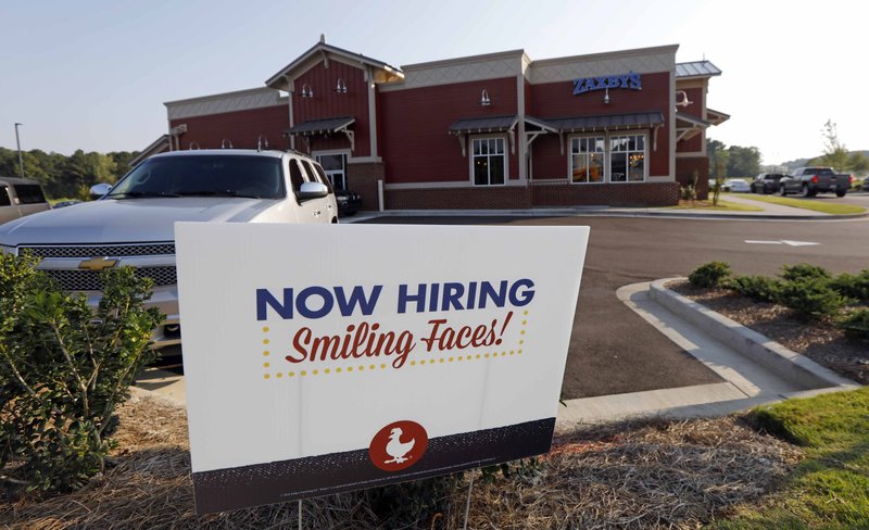 FILE- This July 25, 2018, file photo shows a help wanted sign at a new Zaxby's restaurant in Madison, Miss. On Monday, Dec. 10, the Labor Department reports on job openings and labor turnover for October. (AP Photo/Rogelio V. Solis, File)