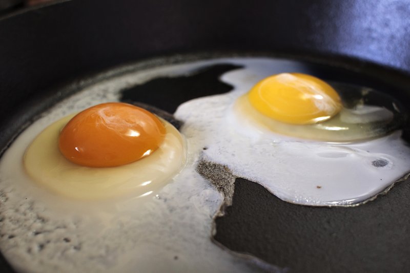 FILE - This undated photo shows the darker orange yolk of a homegrown chicken egg, left, compared with the lighter yolk of a store-bought egg in Gillette, Wyo. Yolk color is primarily determined by the carotenoids _ naturally occurring pigments in plants _ that hens eat, according to Elizabeth Bobeck, a poultry nutrition professor at Iowa State University. (Pete Rodman/Gillette News Record via AP)