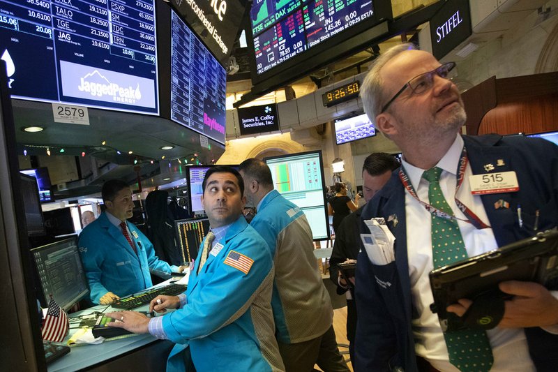 William Geier, Jr., left, and David O'Day work at the New York Stock Exchange, Tuesday, Dec. 11, 2018, in New York. Stock markets around the world spiked higher Tuesday after Wall Street rebounded amid hopes the U.S. and China are back negotiating over their trade dispute. (AP Photo/Mark Lennihan)