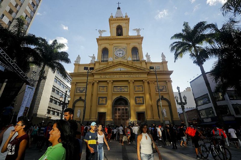 People walk outside the Metropolitan Cathedral after a fatal shooting in Campinas, Brazil, on Tuesday. A gunman fatally shot at least four people and injured four others.
