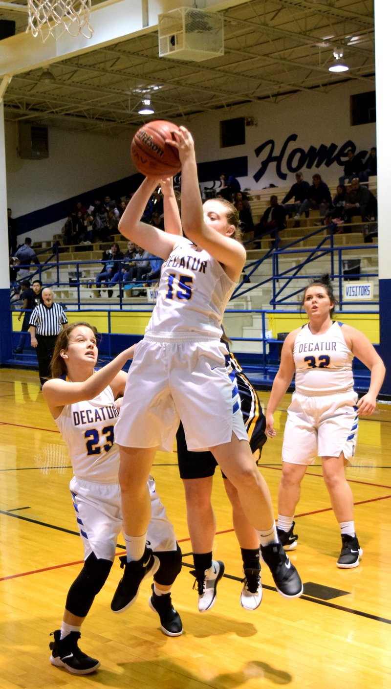 Westside Eagle Observer/MIKE ECKELS Annabelle Schopper (Decatur 15) brings down a rebound late in the second quarter of the Decatur-Fayetteville Haas Hall conference basketball contest at Peterson Gym in Decatur Dec. 4. Schopper led the scoring effort with 19, enabling the Lady Bulldogs to win their conference opener, 55-28, against the Lady Mastiffs.