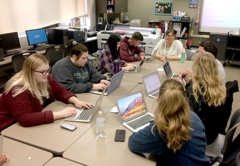 Janelle Jessen/Herald-Leader Teacher Angie Amos, center, led small business operations students at Siloam Springs High School in a planning meeting last week. The class has started a student-run marketing firm called Panther Creative that manages design and film students.