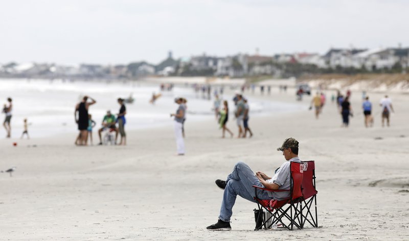  In this Sept. 13, 2018, file photo, beach goers hang out at the Isle of Palms, S.C., as Hurricane Florence spins out in the Atlantic ocean. Environmental groups plan to sue the Trump administration over offshore drilling tests, launching a legal fight against a proposal that has drawn bipartisan opposition along the Atlantic Coast, two people with direct knowledge of the pending litigation told The Associated Press on Monday, Dec. 10. (AP Photo/Mic Smith, File)