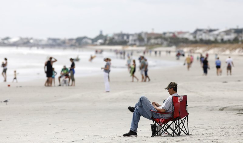 In this Sept. 13, 2018, file photo, beach goers hang out at the Isle of Palms, S.C., as Hurricane Florence spins out in the Atlantic ocean. Environmental groups plan to sue the Trump administration over offshore drilling tests, launching a legal fight against a proposal that has drawn bipartisan opposition along the Atlantic Coast, two people with direct knowledge of the pending litigation told The Associated Press on Monday, Dec. 10. (AP Photo/Mic Smith, File) story.lead_photo.caption