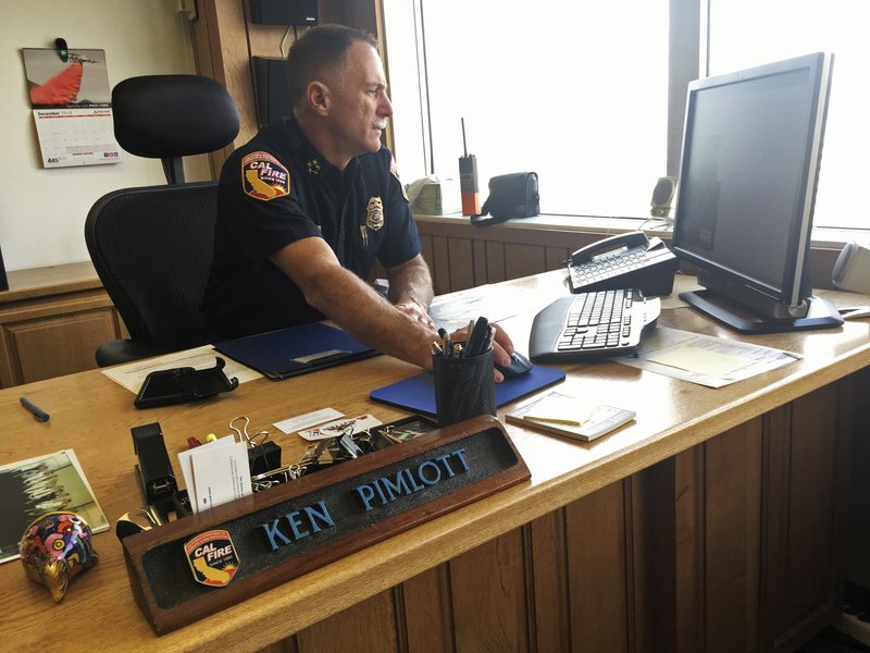In this photo taken Monday, Dec. 10, 2018, California Department of Forestry and Fire Protection Director Ken Pimlott works at his desk in his office in Sacramento, Calif. Pimlott told The Associated Press he prepares to retire on Friday, Dec. 14, 2018, after a 30-year career. (AP Photo/Haven Daley)