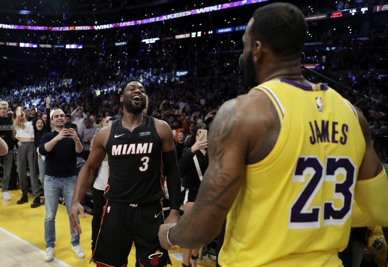 Miami Heat guard Dwyane Wade, left, smiles at Los Angeles Lakers' LeBron James (23) at the end of an NBA basketball game Monday, Dec. 10, 2018, in Los Angeles. (AP Photo/Marcio Jose Sanchez)