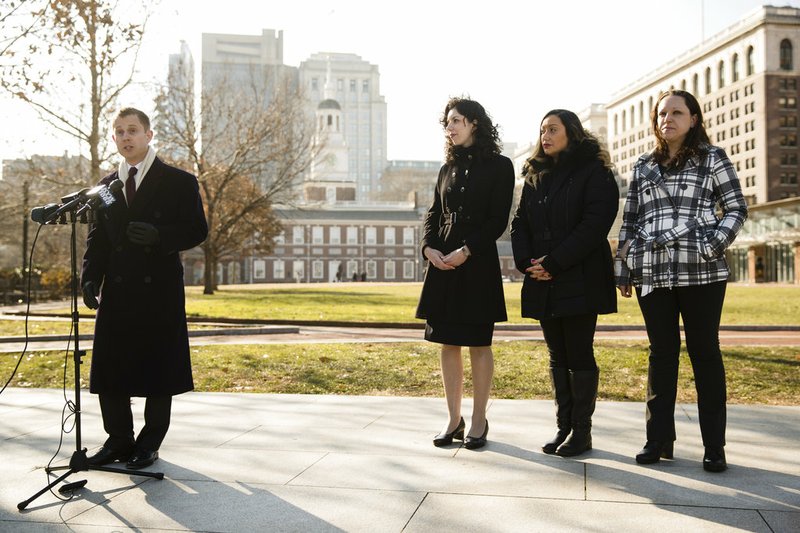 Attorneys with the Institute for Justice, Andrew Ward, left, and Erica Smith, center, take part in a news conference with Courtney Haveman, second from right, and Amanda Spillane, in view of Independence Hall in Philadelphia, Wednesday, Dec. 12, 2018. Haveman and Spillane, who were denied licenses to work as estheticians as a result of running afoul of a state good moral character rule- due to past drug-related convictions- are challenging the regulation in a lawsuit. (AP Photo/Matt Rourke)