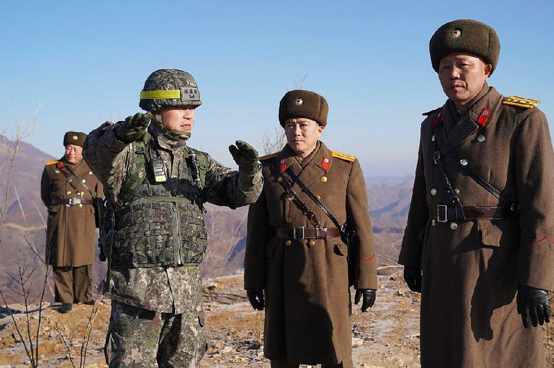 South Korean army Col. Yun Myung-shick (left) talks with North  Korean soldiers during Wednesday’s inspection of a dismantled North Korean guard post inside the Demilitarized Zone. 