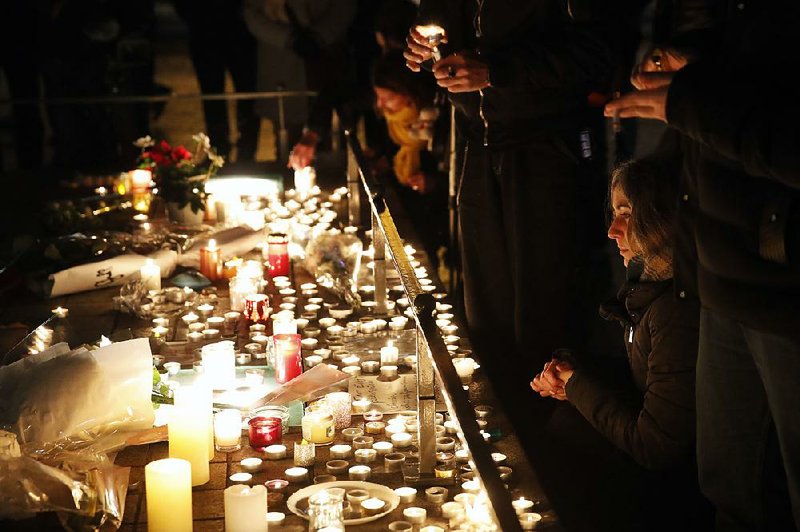 People in Strasbourg, France, pay their respects and light candles Wednesday for victims of a deadly attack Tuesday on the city’s Christmas market. The suspect being sought in the attack has a record of 27 convictions in three countries. 