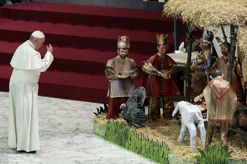 Pope Francis prays Wednesday in front of a Nativity scene during his weekly general audience at the Vatican. 