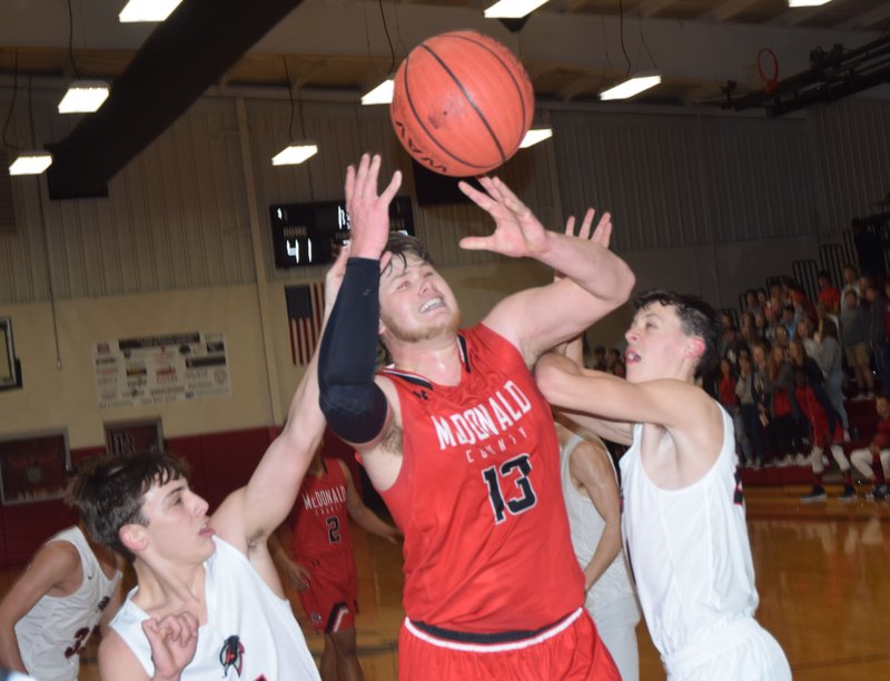 RICK PECK/SPECIAL TO MCDONALD COUNTY PRESS McDonald County's Cooper Reece gets fouled from both sides while going up for a shot during the Mustangs' 66-53 loss on Dec. 6 to Pea Ridge in the opening round of the Battle at the Ridge at Pea Ridge High School.