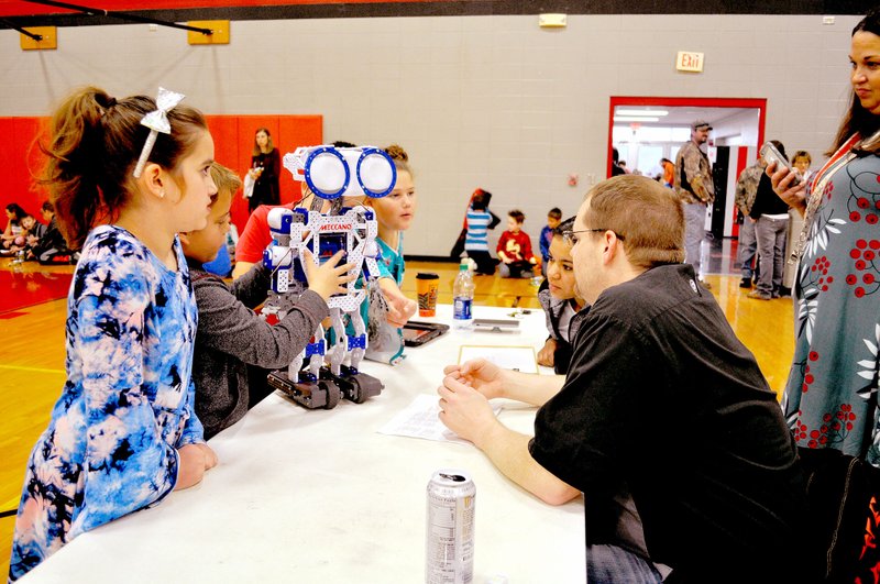 RACHEL DICKERSON/MCDONALD COUNTY PRESS Judges from Walmart look at a robot presented by a third-grade team from Anderson Elementary School during the third annual Robot Fest at McDonald County High School.