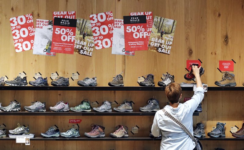 In this Nov. 13, 2018, file photo, a shopper looks at hiking boots during a sale in REI Co-op's flagship store in Seattle. U.S. consumer prices were unchanged in November, the best performance since prices actually fell eight months ago. (AP Photo/Elaine Thompson, File)