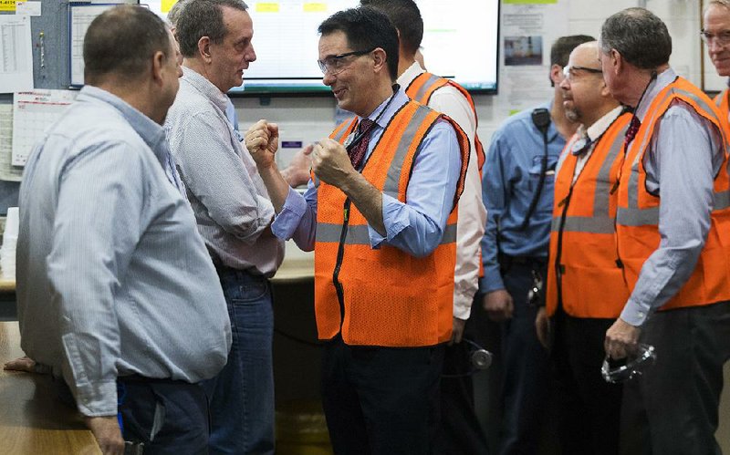 Wisconsin Gov. Scott Walker (right) talks with workers Thursday at Kimberly-Clark’s Cold Spring plant in Neenah, Wis. “If there is any talk about a legacy, I want this to be my legacy,” Walker said of the $28 million incentive package to keep the plant from closing. The agreement means a similar plant in Conway will be shut down by 2021. 