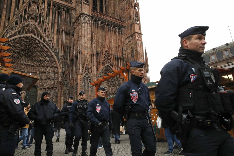 French riot police officers patrol outside the cathedral as the Christmas market reopens in Strasbourg, eastern France, Friday, Dec.14, 2018. The man authorities believe killed three people during a rampage near a Christmas market in Strasbourg died Thursday in a shootout with police at the end of a two-day manhunt, French authorities said. (AP Photo/Christophe Ena)