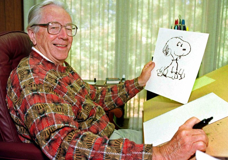 In this Feb. 12, 2000, file photo, cartoonist Charles M. Schulz displays a sketch of his beloved character "Snoopy" in his office in Santa Rosa, Calif. Apple has struck a deal with DHX Media to produce new "Peanuts" content. The global children's content and brands company will develop and produce original programs for Apple including new series, specials and shorts based on the beloved characters. "Peanuts" was created by Schulz in 1950. (AP Photo/Ben Margot, File)