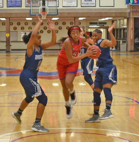 Against Metropolitan Community College on Tuesday, Lillie Moore (left) drives. The sophomore led No. 6 Kansas City Kansas Community College to a 98-86 win. Moore had 21 points and 13 rebounds, while Young scored 15 points and grabbed 12 rebounds. The sophomores are in the second season with Kansas City-based Lady Blue Devils.