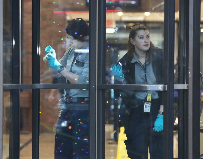 Little Rock police technicians process fingerprints after a robbery Friday at the Arvest Bank at West Capitol Avenue and Broadway. The robber made off with some cash. A suspect, identified as Sheaquonda Hinton, 37, of Little Rock was arrested a short time later after a witness reported seeing the robber getting into a taxi.