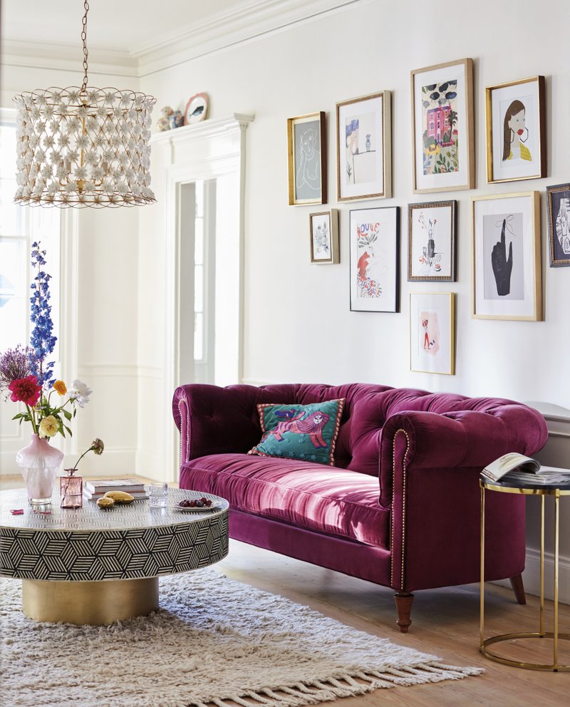 This undated photo provided by Anthropologie shows the Atelier chesterfield, a chic option with a rich mulberry hue, velvet upholstery and a deep comfy structure. Pair it with minimalist contemporary accessories to give it center stage, or play off its traditional aesthetic with lots of pattern and eclectic accompaniments. (Anthropologie via AP)