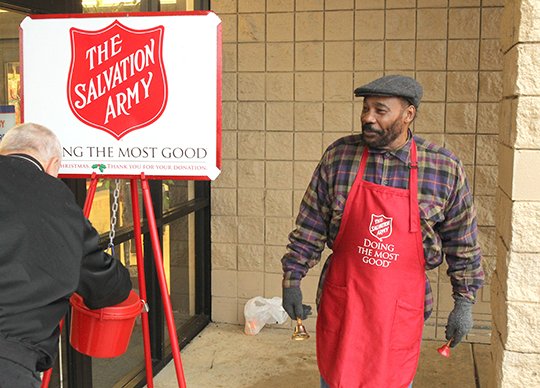 The Sentinel-Record/Richard Rasmussen DONATIONS NEEDED: Keith Patton, right, mans a Salvation Army kettle outside Hobby Lobby on Central Avenue Friday as part of the organization's annual Red Kettle Campaign to raise funds for its programs and services. Donations have been slow this season and only a few days remain in the campaign, Captain Bradley Hargis said this week.