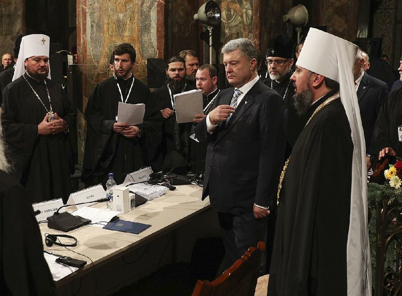 Ukrainian President Petro Poroshenko (center) attends a private synod Saturday at the St. Sophia Cathedral in Kiev, where Ukrainian Orthodox leaders approved the charter for a unified, independent church. Metropolitan Epiphanius (right) was chosen to lead the new church.