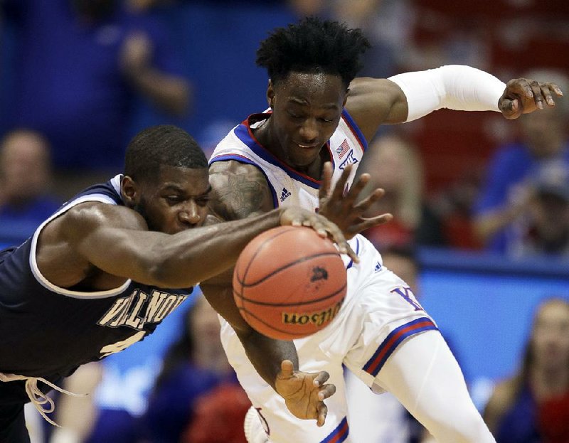 Kansas guard Marcus Garrett (right) and Villanova forward Eric Paschall try to come up with a loose ball Saturday during the top-ranked Jayhawks’ 74-71 victory over the No. 17 Wildcats in Lawrence, Kan.