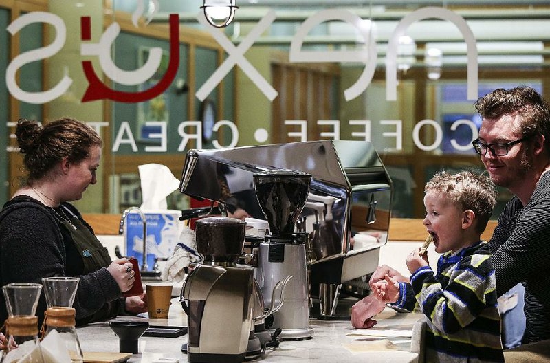 Abigaile Brown, left, brews a coffee for Logan Garrett of Little Rock, as his son Sage, 4, munches on a cookie during the grand opening of the Nexus Nook inside the Main Library Saturday, Dec 15, 2018, in Little Rock. 