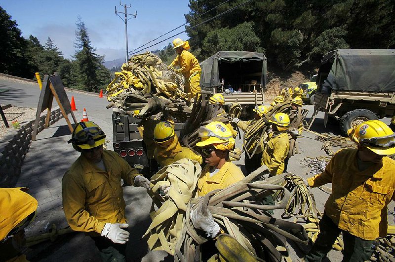 Members of the California National Guard help load fire hoses in Palo Colorado Canyon, Calif., in August 2016 as the Soberanes wildfire rages in the area.