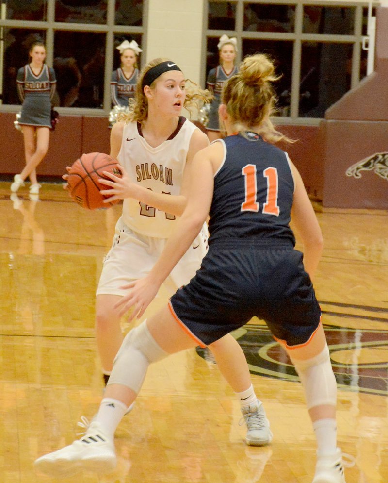 Graham Thomas/Siloam Sunday Siloam Springs sophomore Sydney Moorman, left, looks to make a play as Rogers Heritage junior Brianna Frazier defends on the play during Thursday's game inside Panther Activity Center. The Lady War Eagles rallied in the fourth quarter to defeat Siloam Springs 46-39.