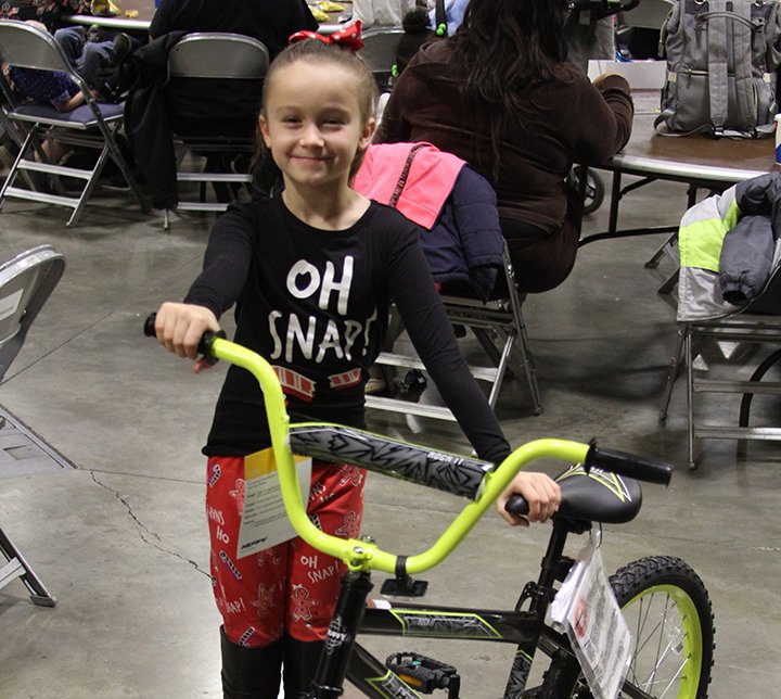 The Sentinel-Record/Tanner Newton NEW BIKE: Lylie Shirley proudly shows the bike that she won Saturday during the 33rd annual Christmas for Kids event at the Hot Springs Convention Center.