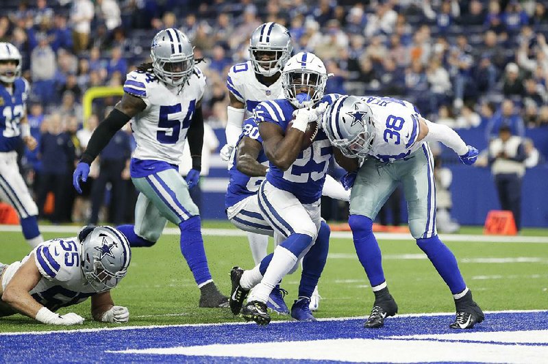 Indianapolis Colts running back Marlon Mack (center) scores on a 6-yard run in the third quarter Sunday against the Dallas Cowboys at Lucas Oil Stadium in Indianapolis. Mack rushed for a career-high 139 yards and two touchdowns in the Colts’ 23-0 victory over the Cowboys. The Colts have won seven of their past eight games to remain in the AFC playoff hunt.