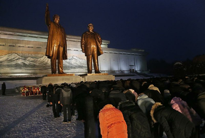North Koreans bow at the bronze statues of the late leaders Kim Il Sung and Kim Jong Il on Sunday in Pyongyang. 