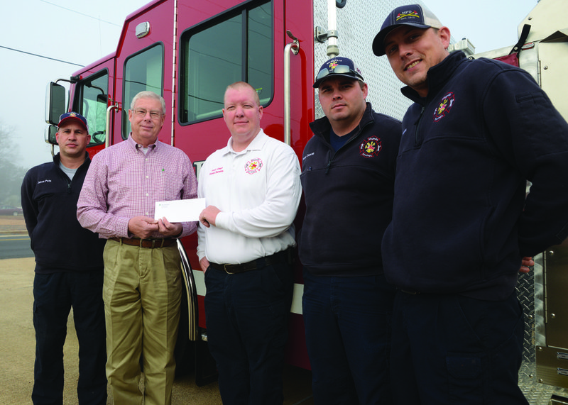Bobby Catrett (second from left), southwest operations manager at Weyerhaeuser in Magnolia, presents a donation to Magnolia Fire Department officers (L-R) Cpt. Jason Pate, Assistant Chief Russell Stevens, Firefighter Nolan Duncan, and Lt. Mark Hudgens.