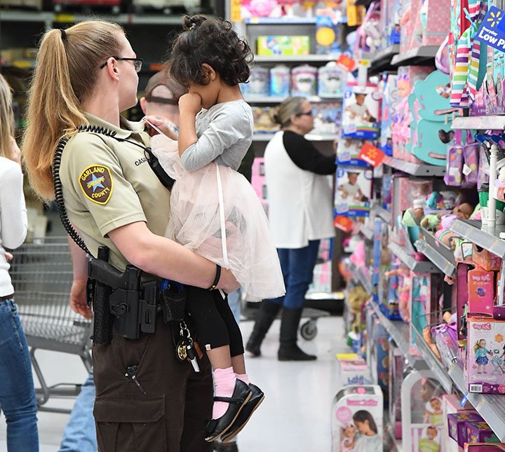 The Sentinel-Record/Grace Brown- Deputy Amanda Casad with the Farland County Shriff's Department helps a little girl frim Hillcrest Children's Home pick out her Christmas gift during the Shop with a Sheriff event at Walmart, 4019 Central Ave., on Sunday, December 16, 2018. 